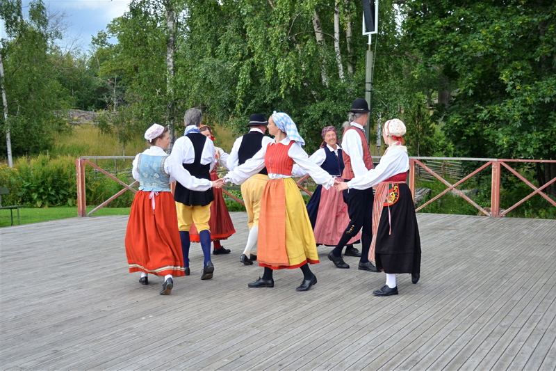 Traditional Swedish folk dancers performing in colorful costumes at the Skansen Open-Air Museum in Stockholm